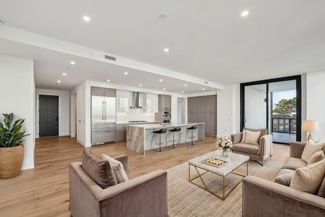 living room featuring light hardwood / wood-style floors and a wall of windows