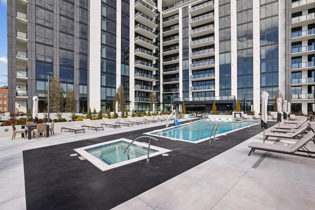 view of swimming pool featuring a community hot tub and a patio