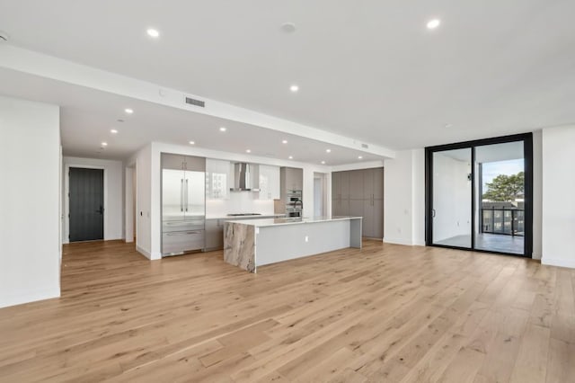 unfurnished living room featuring light wood-type flooring and expansive windows