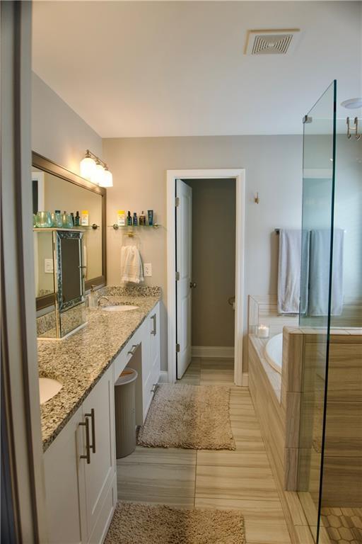 bathroom with vanity and a relaxing tiled tub