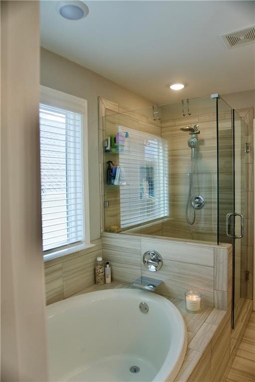 bathroom featuring separate shower and tub