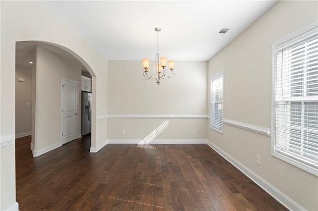 unfurnished dining area with an inviting chandelier and dark hardwood / wood-style floors