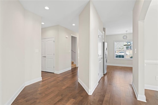 hallway featuring dark wood-type flooring and a chandelier