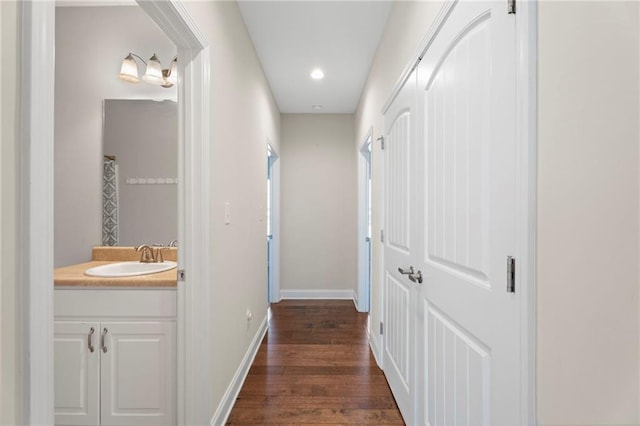 corridor featuring sink and dark wood-type flooring