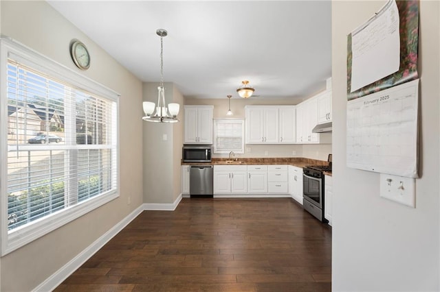 kitchen featuring stainless steel appliances, hanging light fixtures, dark hardwood / wood-style floors, and white cabinets