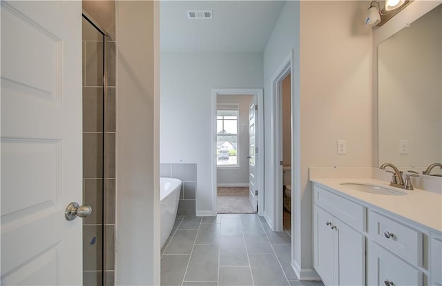 bathroom with tile patterned floors, plus walk in shower, and vanity