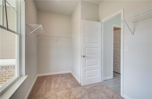 spacious closet featuring light colored carpet