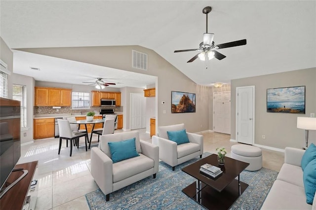 tiled living room with ceiling fan and vaulted ceiling