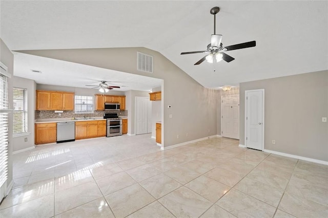 kitchen featuring decorative backsplash, light tile patterned floors, stainless steel appliances, and lofted ceiling