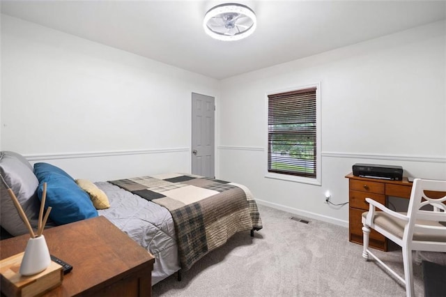 carpeted bedroom featuring baseboards and a desk