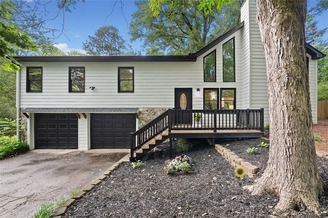 view of front of house with an attached garage, driveway, a chimney, and stone siding