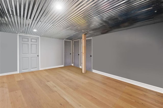 finished below grade area featuring light wood-style flooring and baseboards