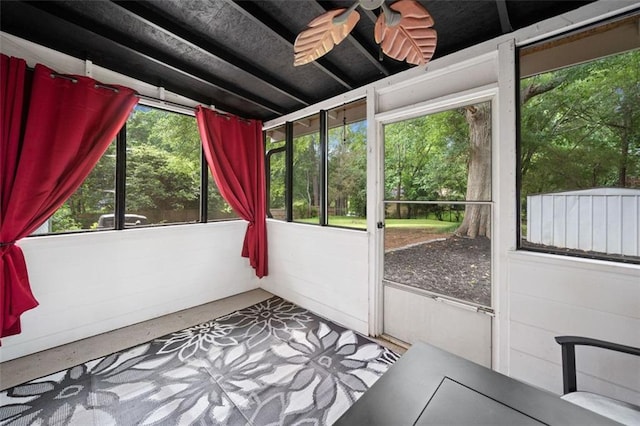 unfurnished sunroom featuring a ceiling fan