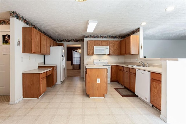 kitchen featuring a center island, light floors, light countertops, a sink, and white appliances