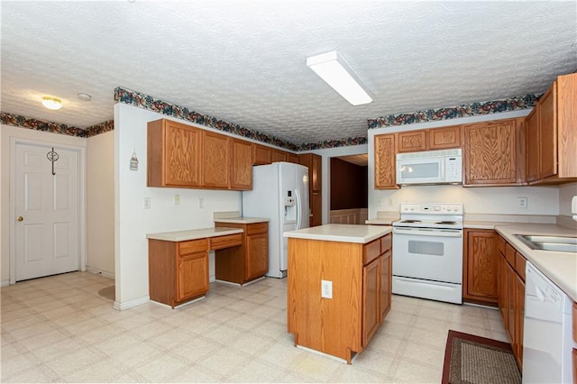 kitchen featuring a center island, light floors, brown cabinetry, a sink, and white appliances