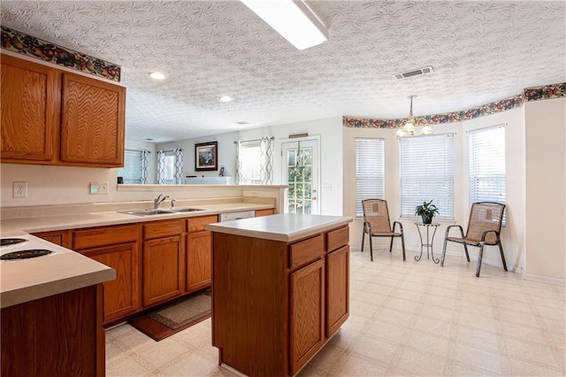 kitchen featuring light floors, a sink, visible vents, and brown cabinets