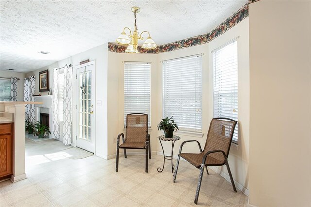 hallway with attic access, baseboards, an upstairs landing, a textured ceiling, and carpet flooring