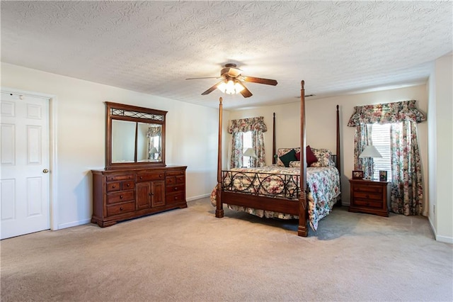 carpeted bedroom featuring a textured ceiling, a ceiling fan, and baseboards