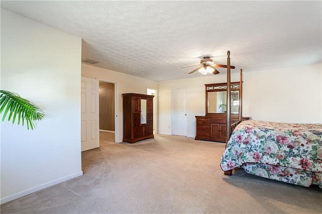 bedroom featuring visible vents, baseboards, a ceiling fan, light colored carpet, and a textured ceiling