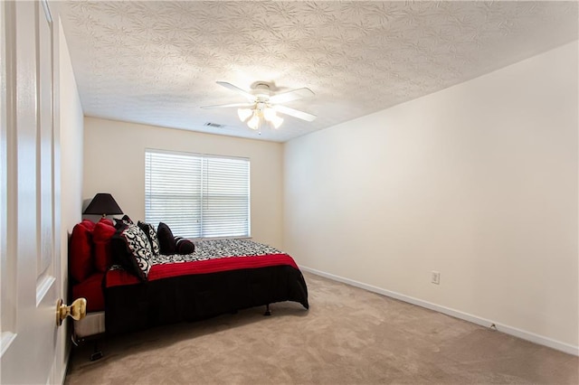 carpeted bedroom with baseboards, visible vents, ceiling fan, and a textured ceiling