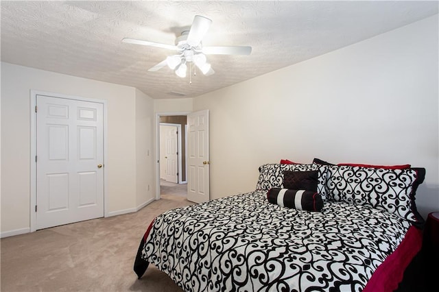 carpeted bedroom featuring a textured ceiling, ceiling fan, and baseboards