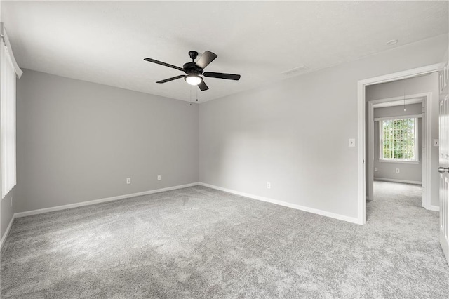 spare room featuring light carpet and ceiling fan