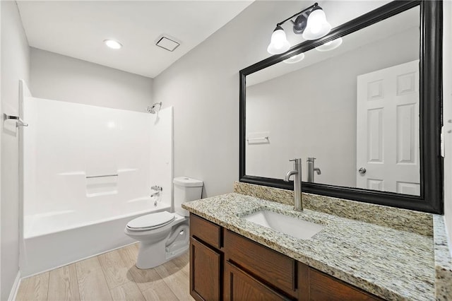 full bathroom with  shower combination, toilet, wood-type flooring, and vanity