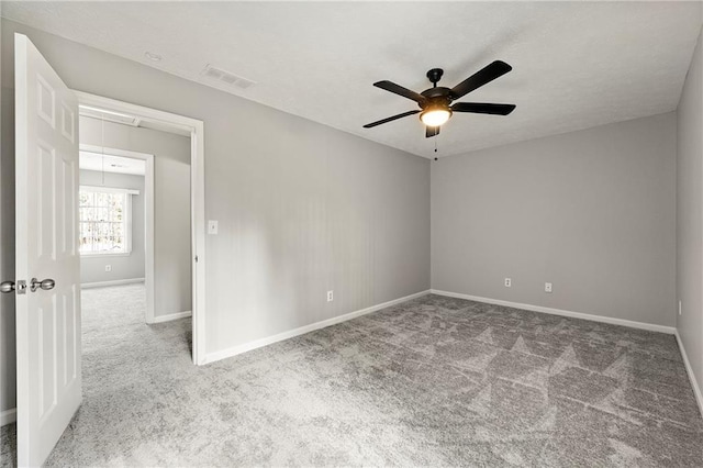 carpeted spare room with ceiling fan