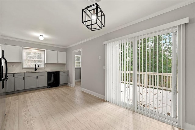 kitchen with gray cabinets, dishwasher, light hardwood / wood-style floors, decorative backsplash, and decorative light fixtures