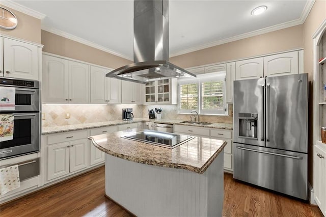 kitchen featuring appliances with stainless steel finishes, island exhaust hood, a sink, white cabinetry, and ornamental molding