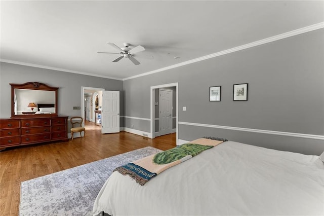 bedroom with crown molding, wood finished floors, baseboards, and ceiling fan