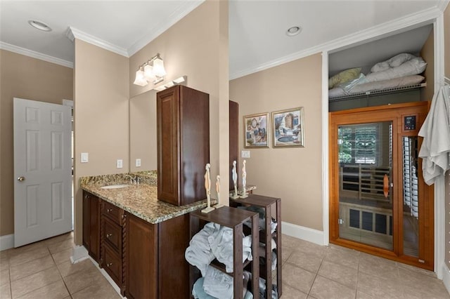 bathroom with tile patterned flooring, baseboards, ornamental molding, and vanity