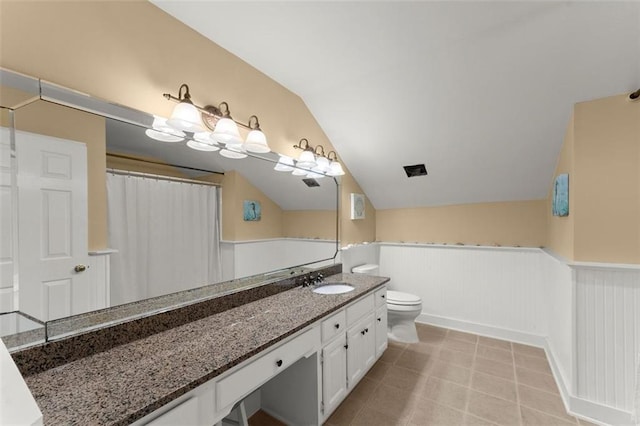 full bath featuring wainscoting, lofted ceiling, toilet, and vanity