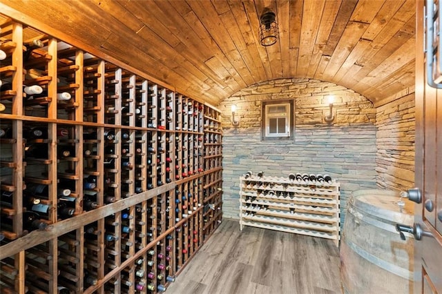 wine area featuring vaulted ceiling, wood ceiling, and wood finished floors