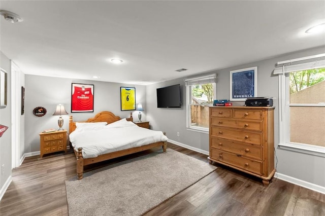 bedroom with wood finished floors, baseboards, multiple windows, and recessed lighting