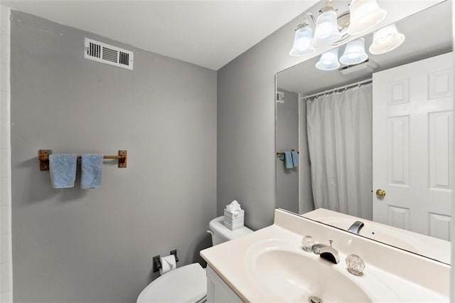 bathroom with toilet, vanity, a shower with curtain, and a chandelier