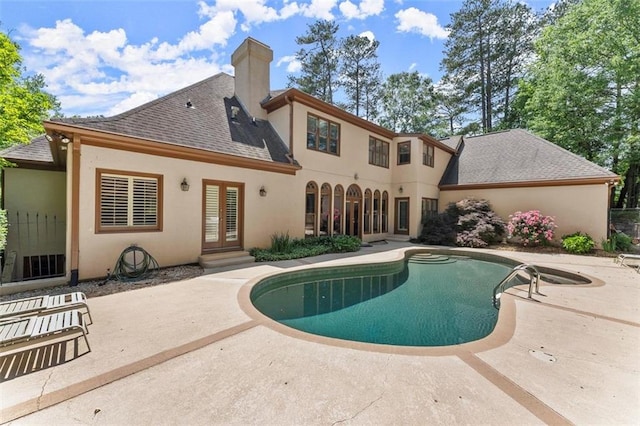 swimming pool featuring french doors and a patio area