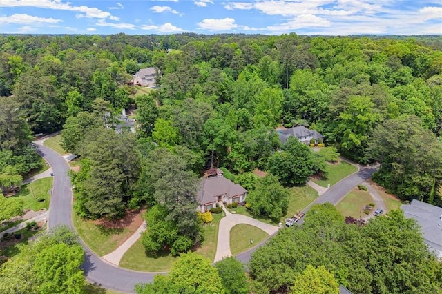 aerial view of property and surrounding area with a heavily wooded area