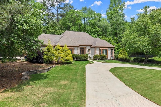 view of front of house featuring curved driveway and a front yard