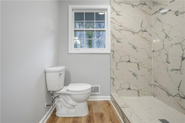 full bathroom featuring a marble finish shower, visible vents, toilet, and wood finished floors