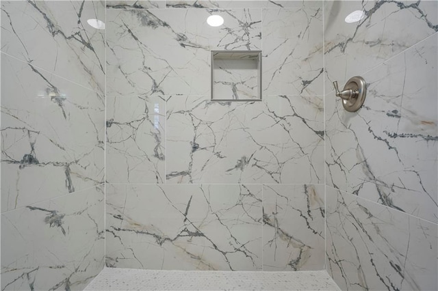 room details featuring a marble finish shower