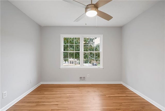 spare room featuring light wood-style floors, visible vents, and baseboards