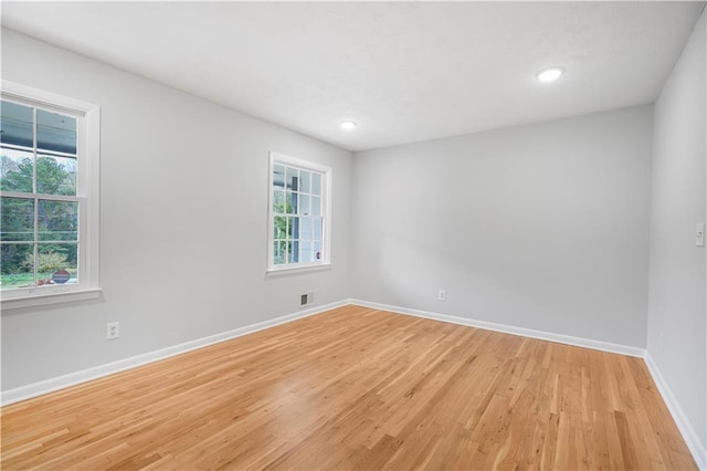 spare room with recessed lighting, light wood-type flooring, visible vents, and baseboards