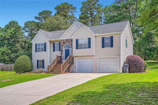3290 Spincaster Way, Loganville, GA 30052 - split foyer home featuring a garage, concrete driveway, and a front yard