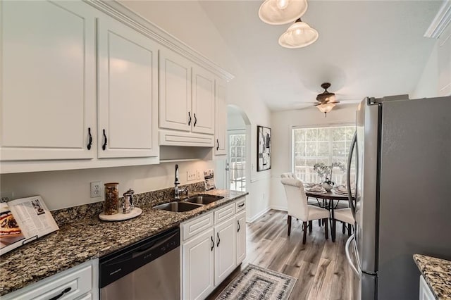 3290 Spincaster Way, Loganville, GA 30052 - kitchen with appliances with stainless steel finishes, ceiling fan, white cabinets, arched walkways, and light wood finished floors