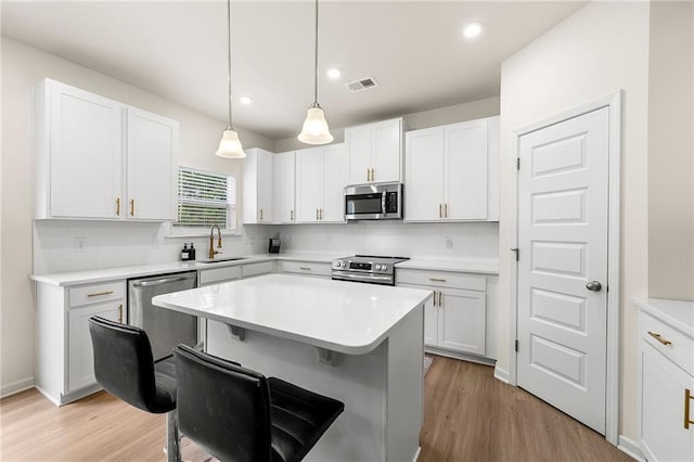 228 Whitneys Way, Dallas, GA 30157 - kitchen featuring appliances with stainless steel finishes, tasteful backsplash, a breakfast bar, white cabinetry, and recessed lighting