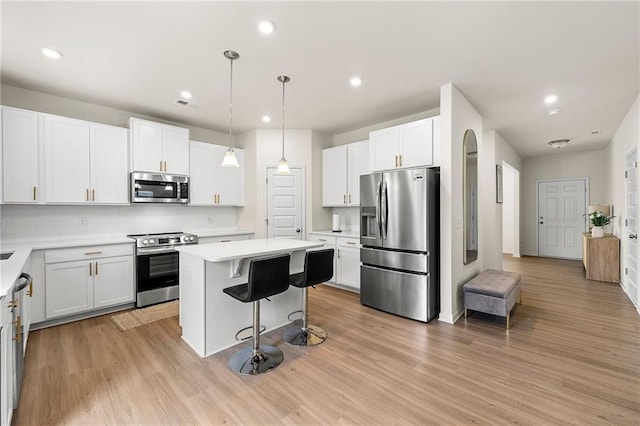 228 Whitneys Way, Dallas, GA 30157 - kitchen featuring stainless steel appliances, a breakfast bar, a center island, light countertops, and white cabinetry