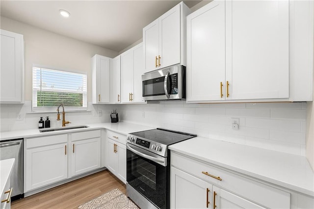 228 Whitneys Way, Dallas, GA 30157 - kitchen with appliances with stainless steel finishes, a sink, white cabinets, decorative backsplash, and recessed lighting