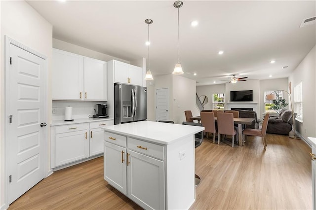 228 Whitneys Way, Dallas, GA 30157 - kitchen with stainless steel refrigerator with ice dispenser, ceiling fan, light countertops, light wood-type flooring, and white cabinetry