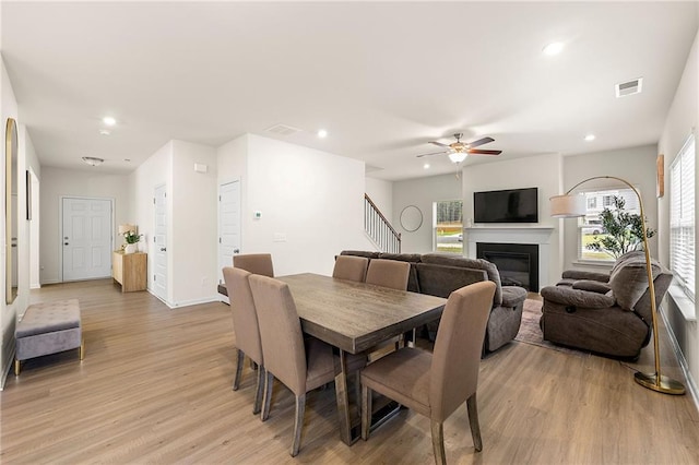 228 Whitneys Way, Dallas, GA 30157 - dining area featuring light wood-type flooring, recessed lighting, a glass covered fireplace, stairway, and a ceiling fan